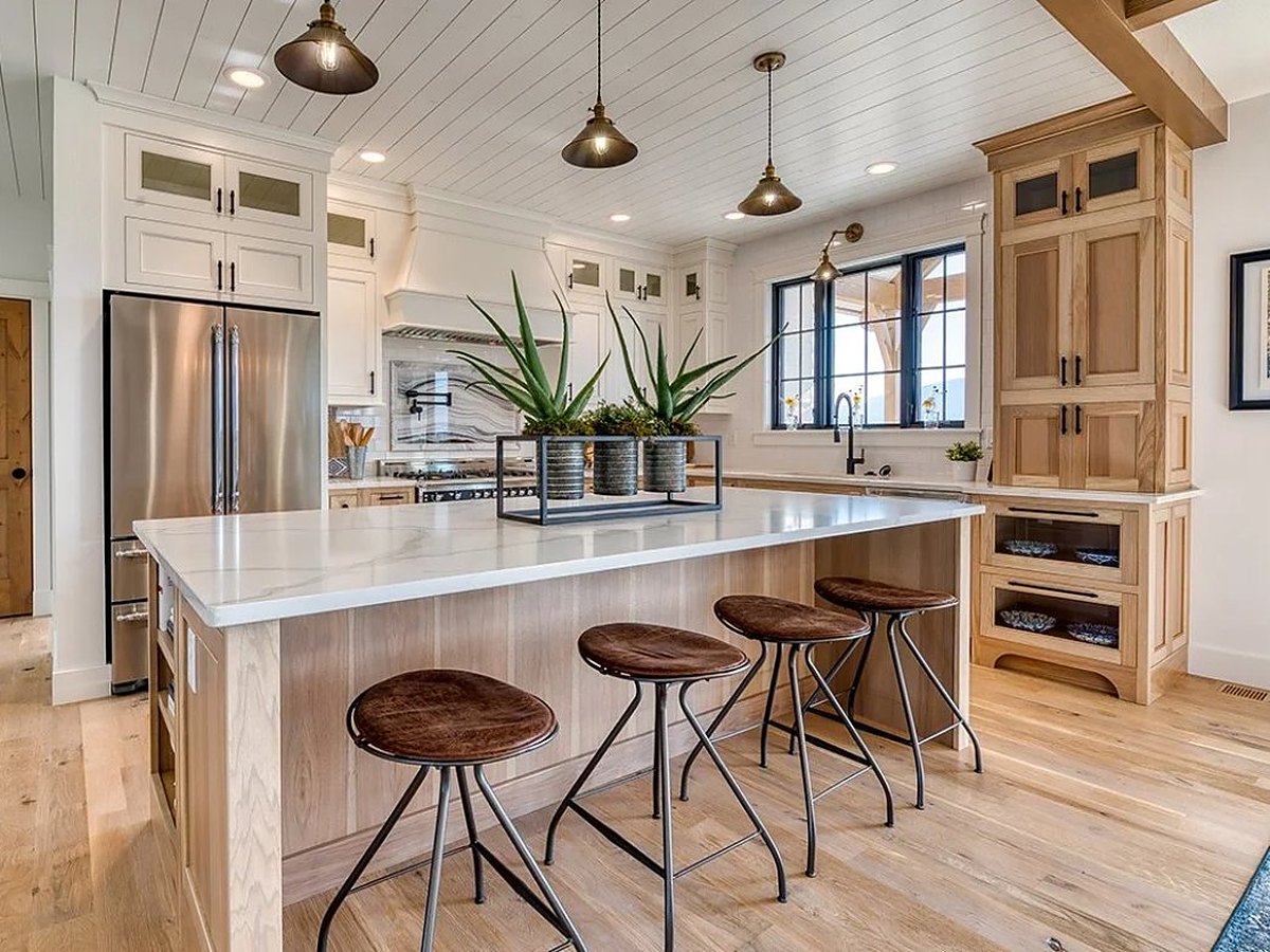Great Northern Cabinetry white inset uppers with custom-stained hickory lowers and island — manufacturer photo