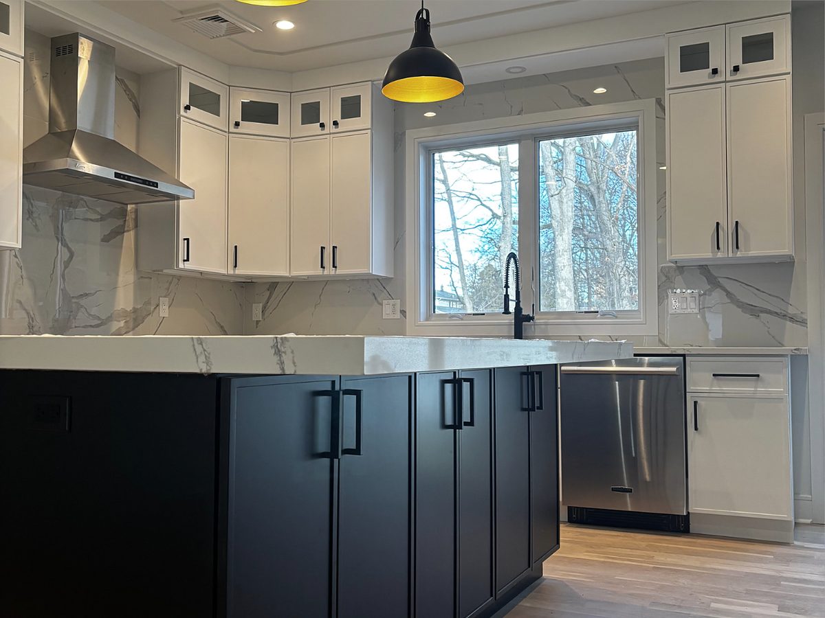 WoodConcept white shaker uppers with a black island and a marble-look slab backsplash — manufacturer photo