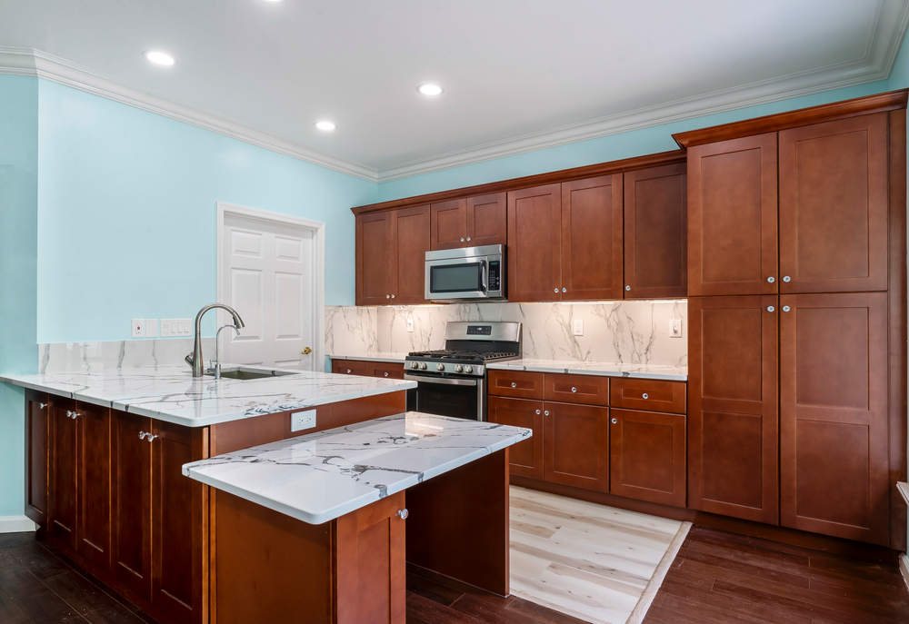 FGM cherry shaker kitchen with a marble-look island — manufacturer photo