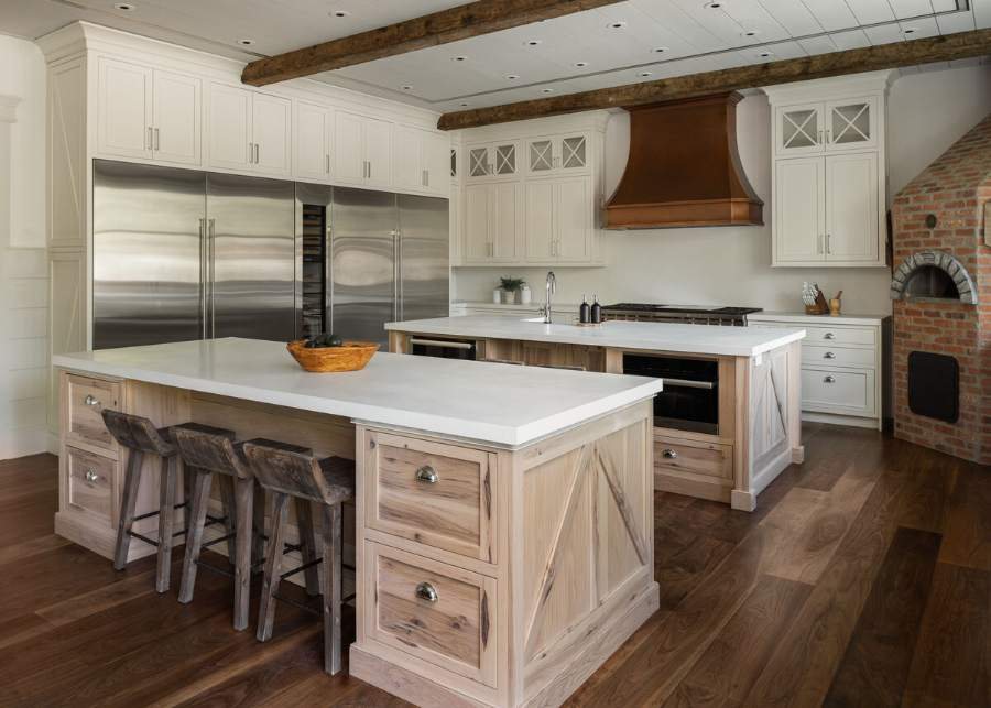 Plain & Fancy white kitchen with a limed-oak island and a wood range hood — manufacturer photo