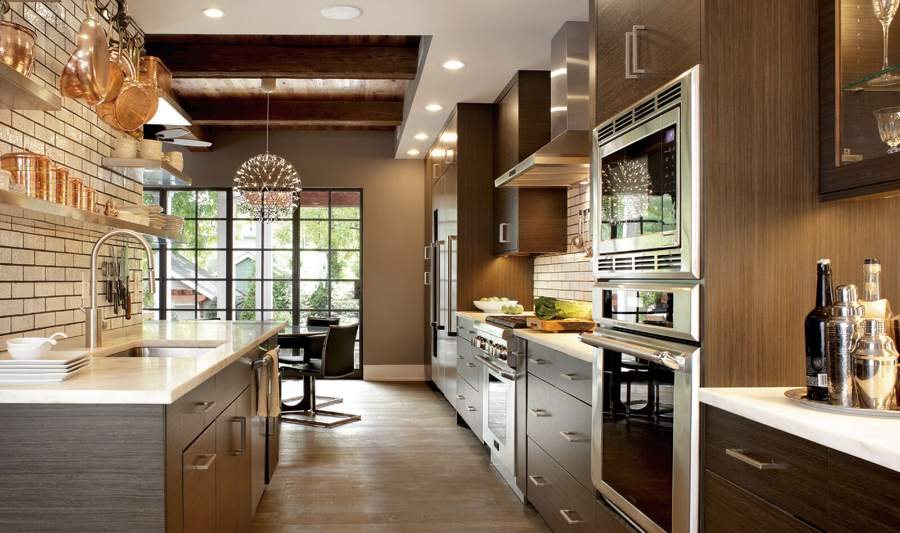 Plain & Fancy walnut slab kitchen with a stainless range wall — manufacturer photo