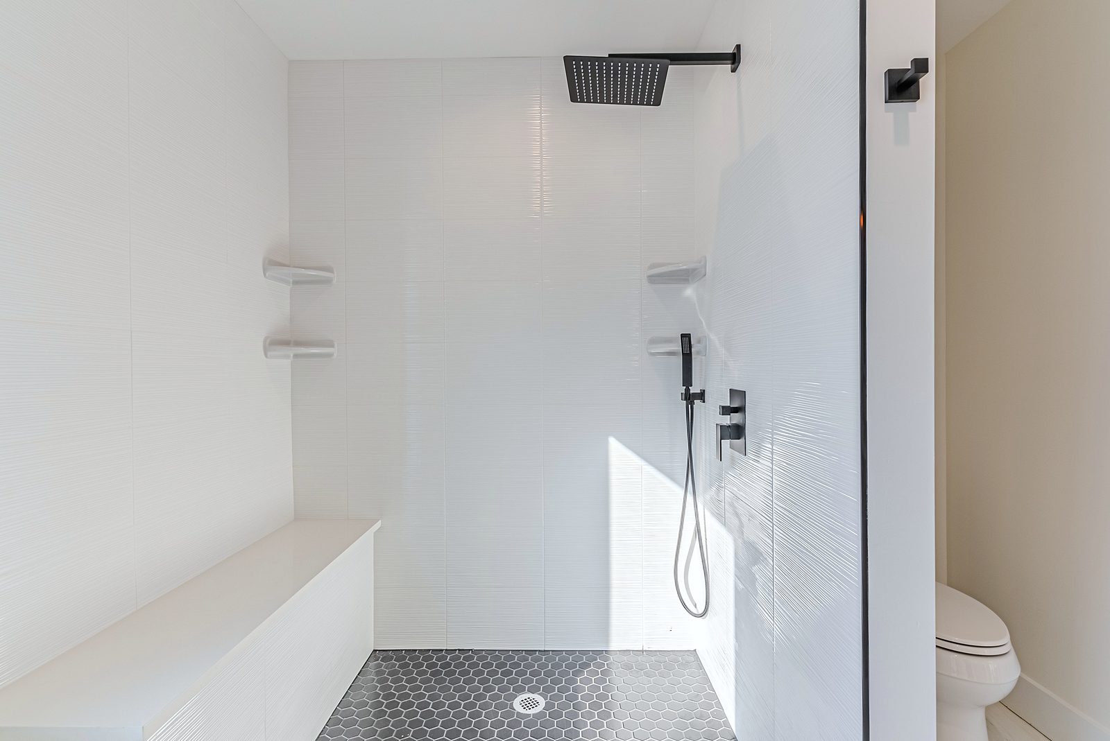White-oak and navy bathroom vanities with a freestanding tub and black fixtures — photo 7