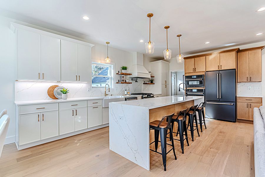 White shaker kitchen with a natural slab island and Calacatta waterfall
