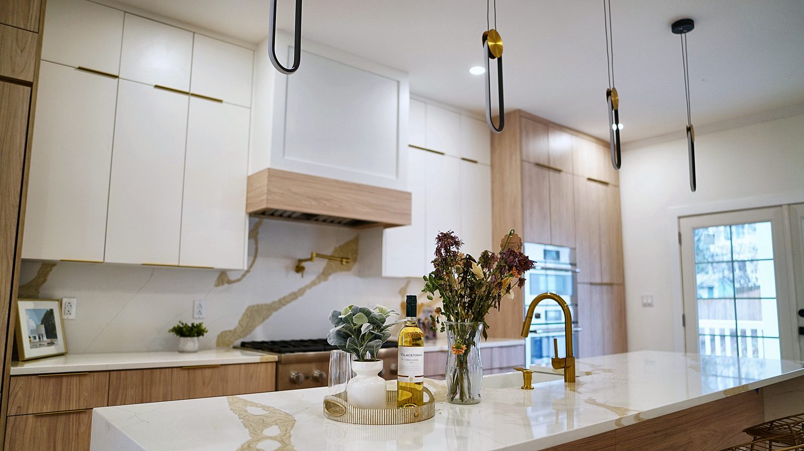 Island with brass faucet and black pendants