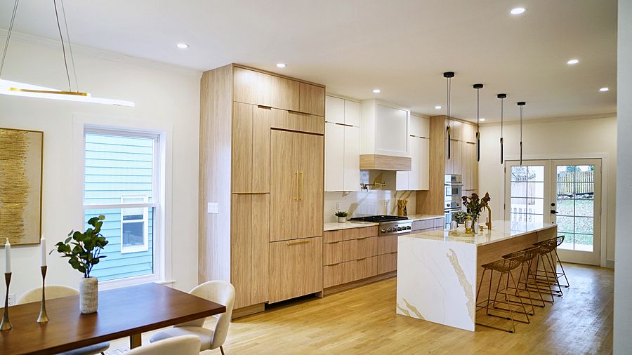 Matte white and rift oak slab kitchen with a Calacatta waterfall island