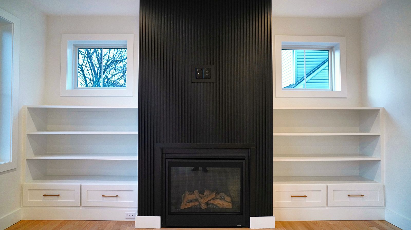 Fluted black fireplace wall with built-ins