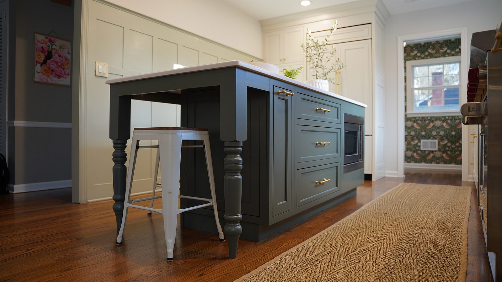The green island on turned legs with a white quartz top and a brass dome pendant