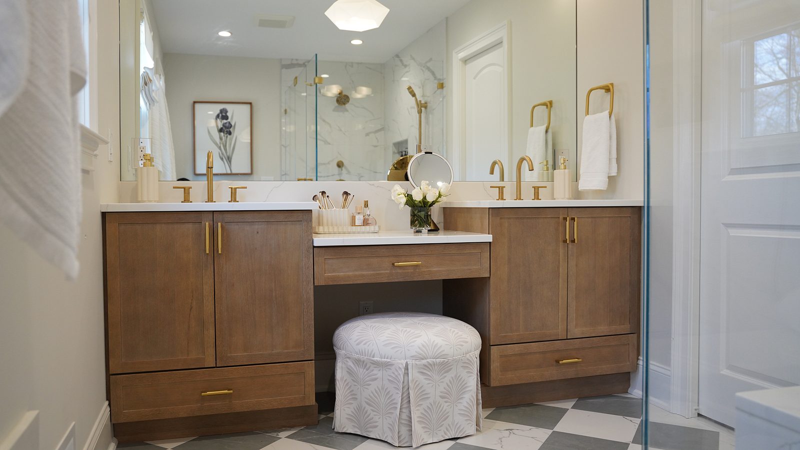 Bath: stained white-oak double vanity with a makeup desk, brass faucets and a checkerboard floor