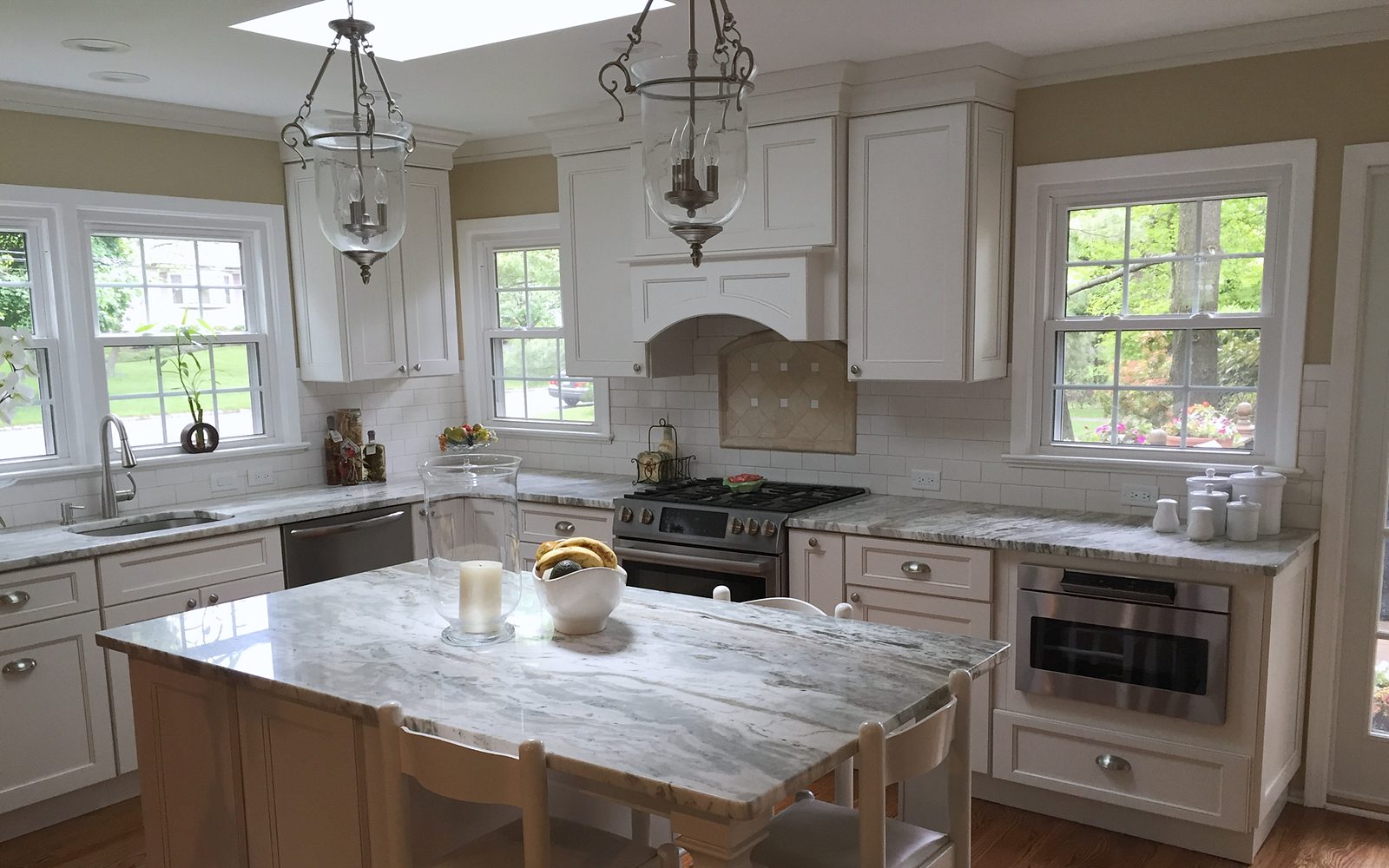Fabuwood Fusion door, Blanc (archive label) — Fabuwood Fusion in Blanc with a granite island and an arched hood