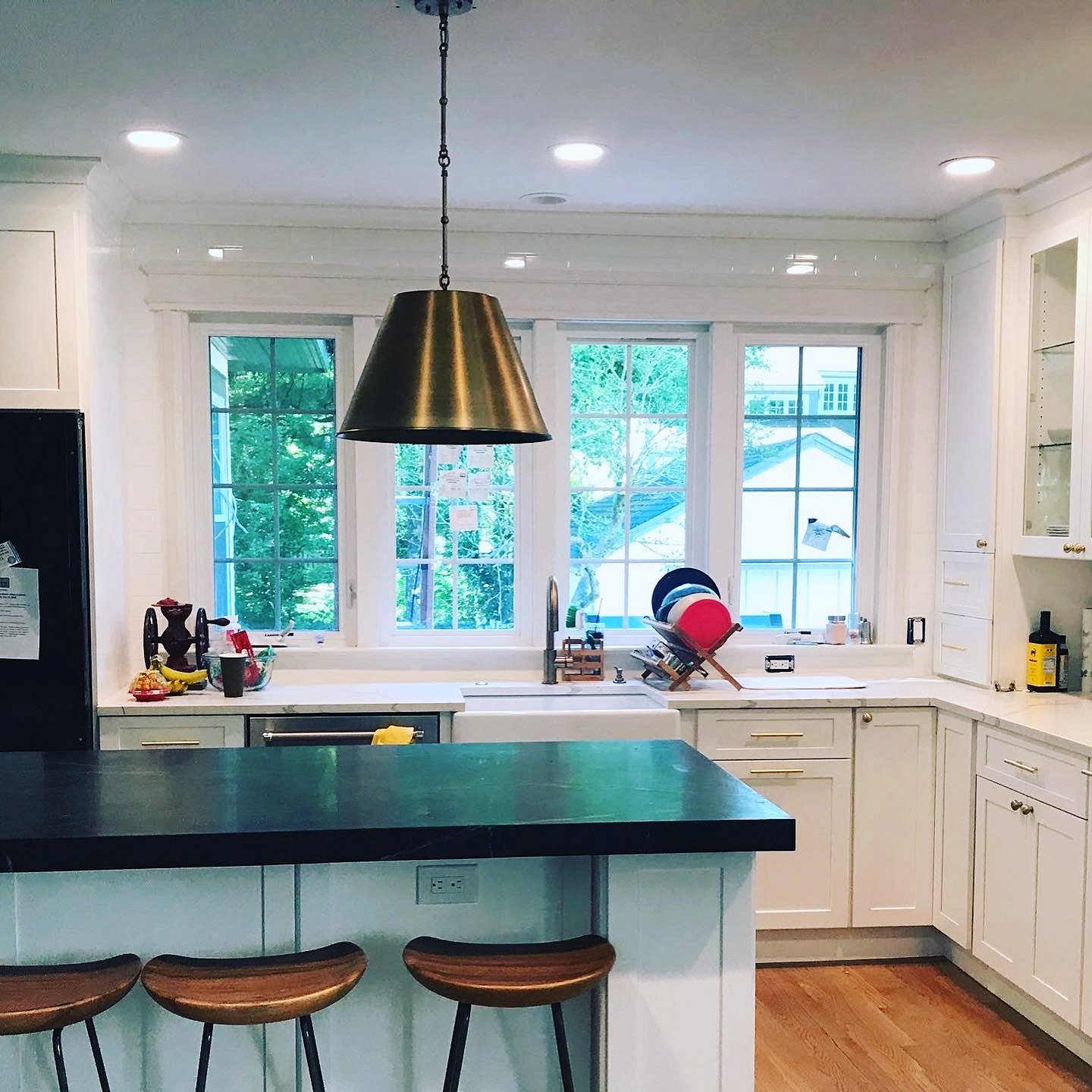 Glass-front upper cabinets — Fabuwood Galaxy in Frost with a dark honed counter and hex tile
