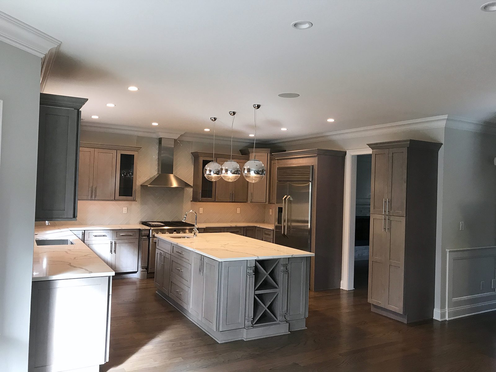 Island with an X wine rack and a Calacatta-look top — Fabuwood Galaxy in Horizon gray with a wine-rack island