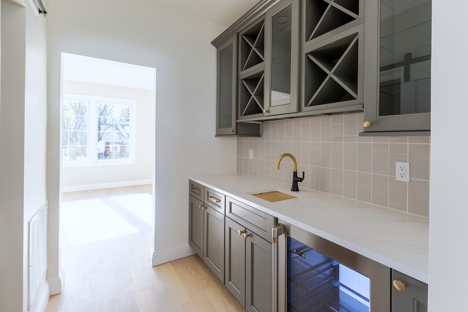 Slate island with brass-and-white dome pendants — Fabuwood Nexus Frost and Slate kitchen with a double crown and a butler’s pantry