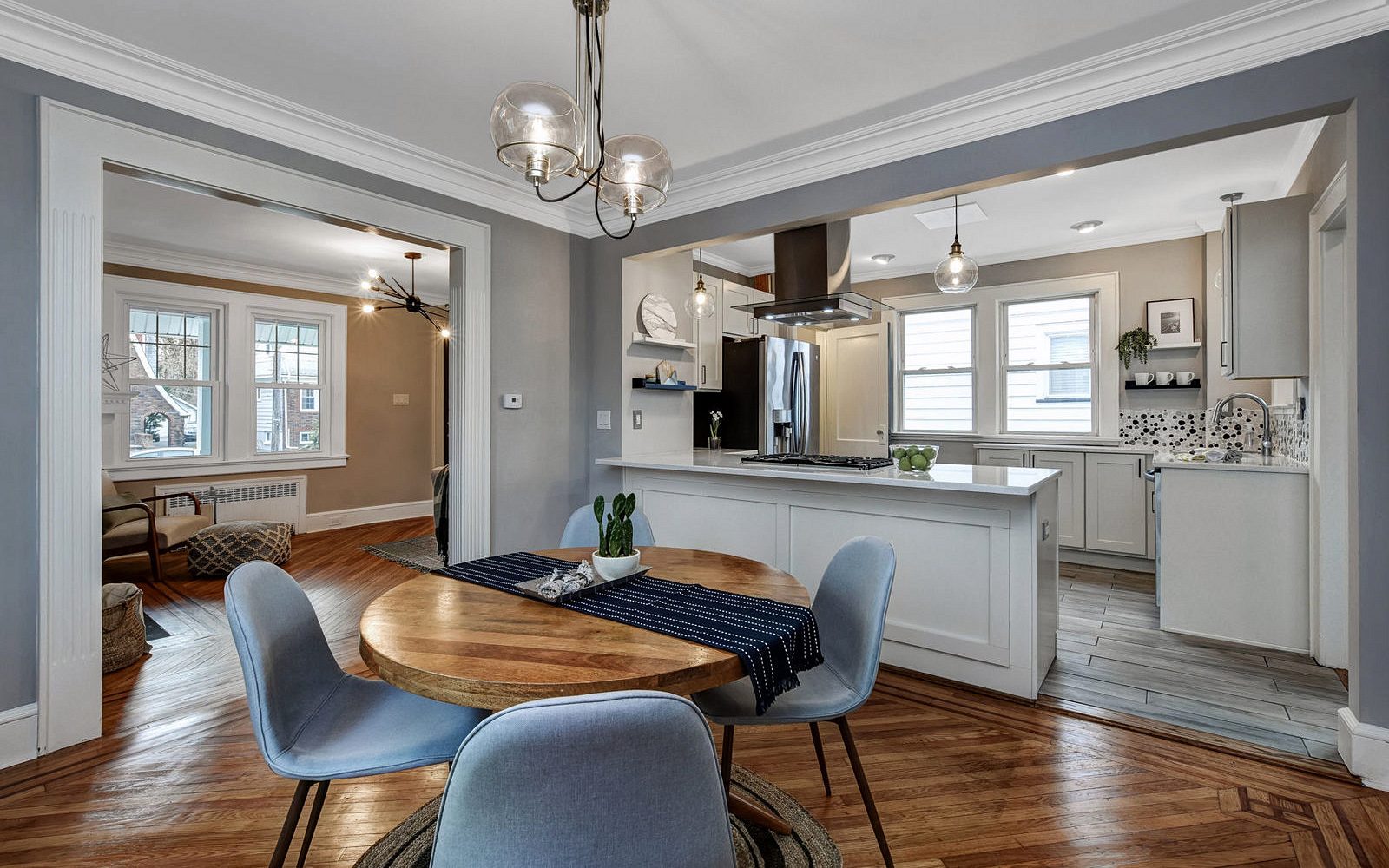 Gray mosaic backsplash, stainless chimney hood — FGM Mercury White kitchen with an espresso island and a mosaic backsplash