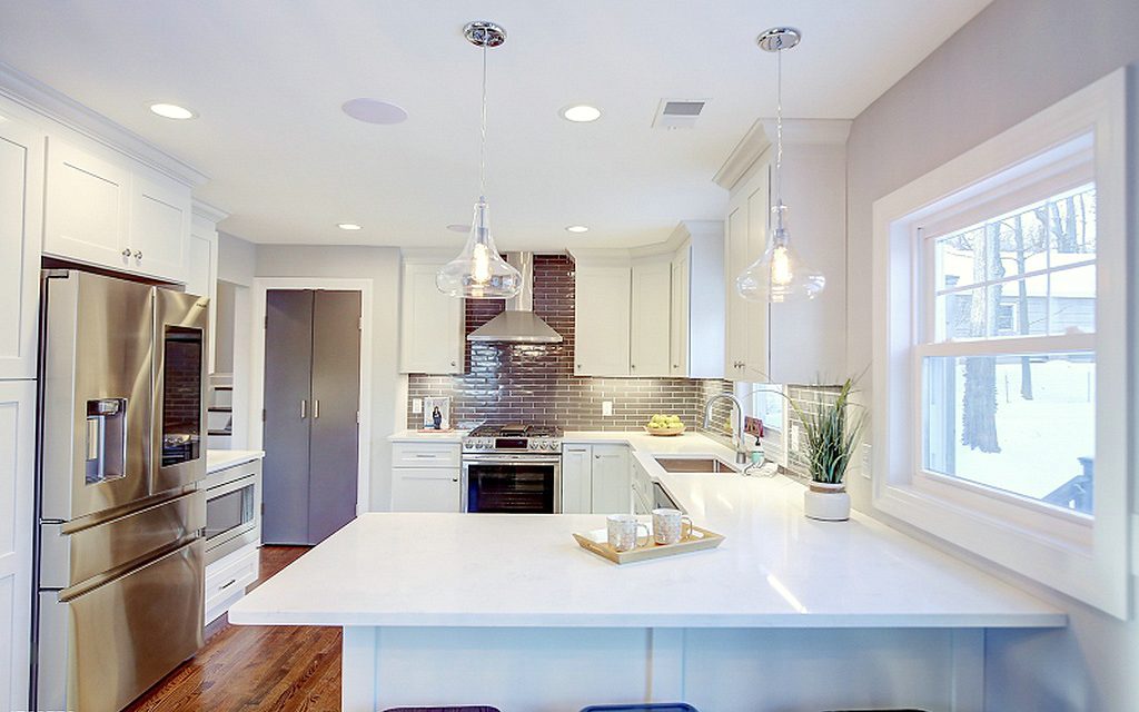 Oak floor — FGM Mercury White kitchen with gray subway tile and an open dining room