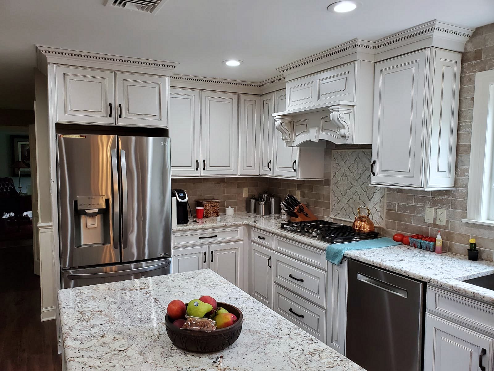 Kabinart Hampton raised-panel kitchen in Polar with an arched hood and granite