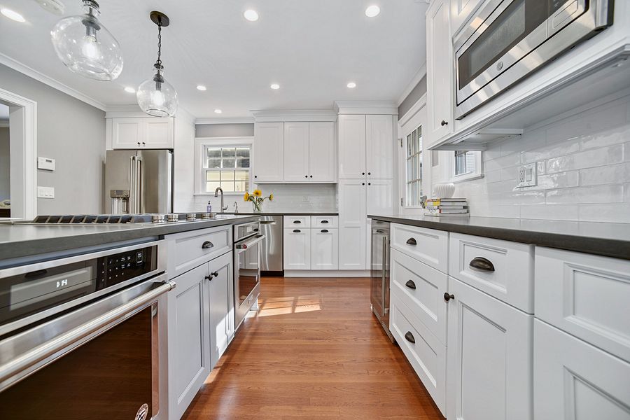 Project 141: Fabuwood white shaker kitchen with a gray island and glass pendants