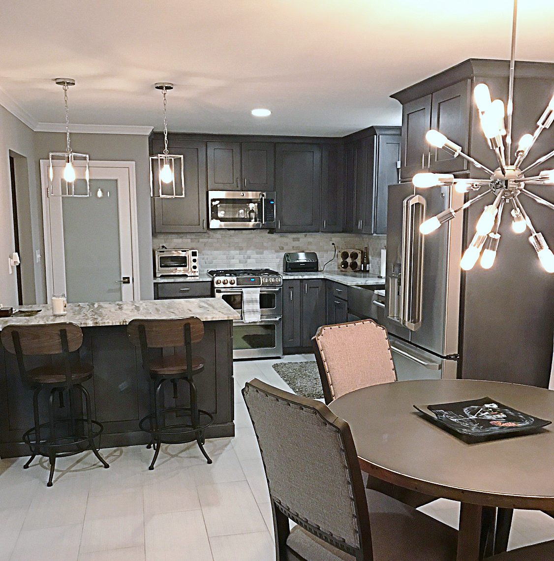 Charcoal gray shaker perimeter and island — Charcoal shaker kitchen with veined granite and a sputnik chandelier