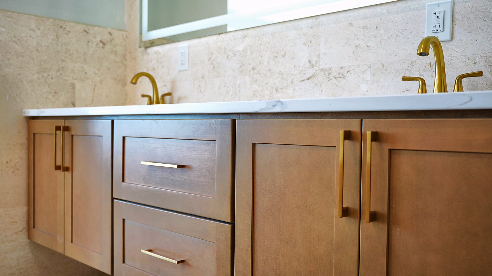 Floating natural-wood vanity with brass faucets