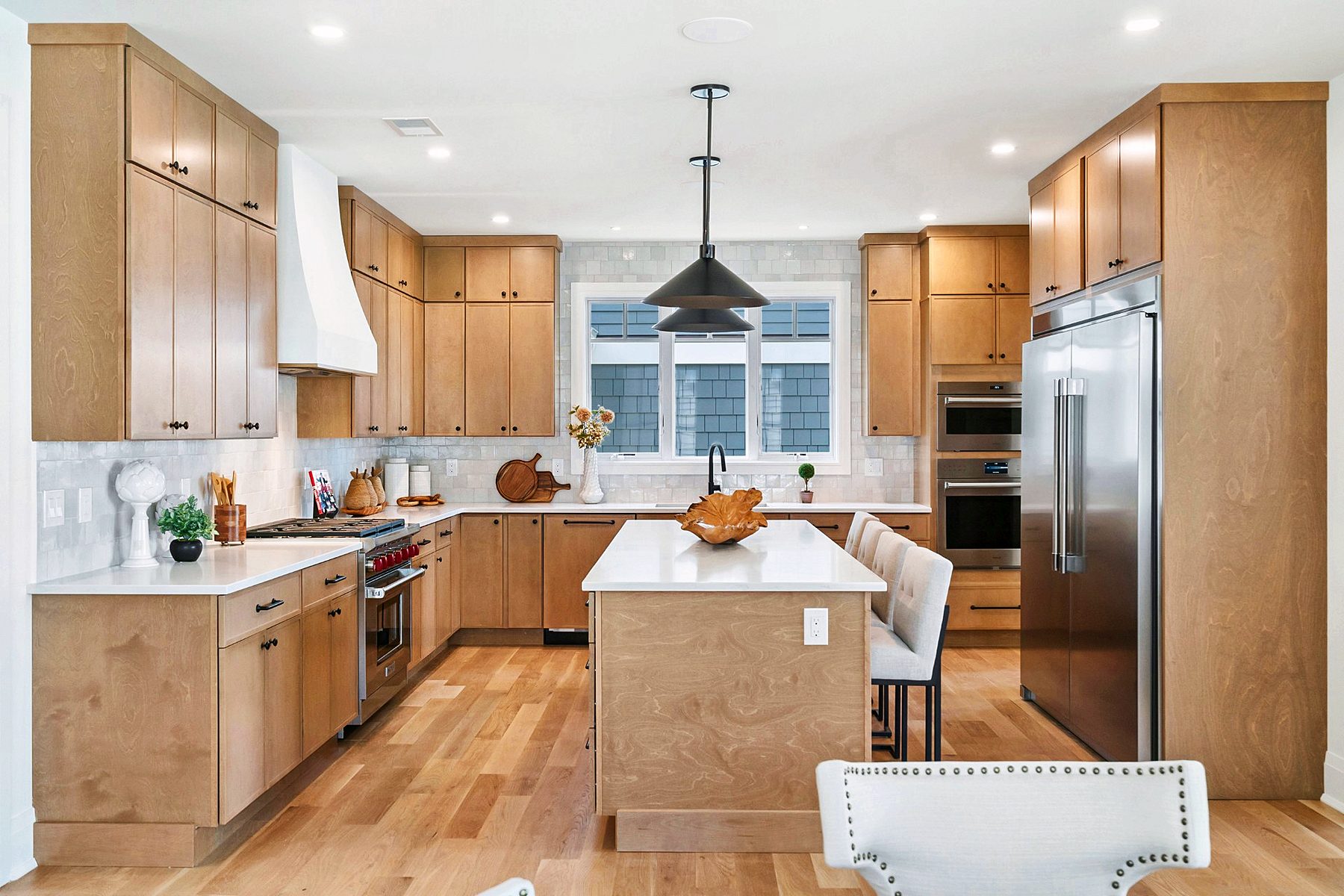 Natural maple kitchen with white hood and island seating