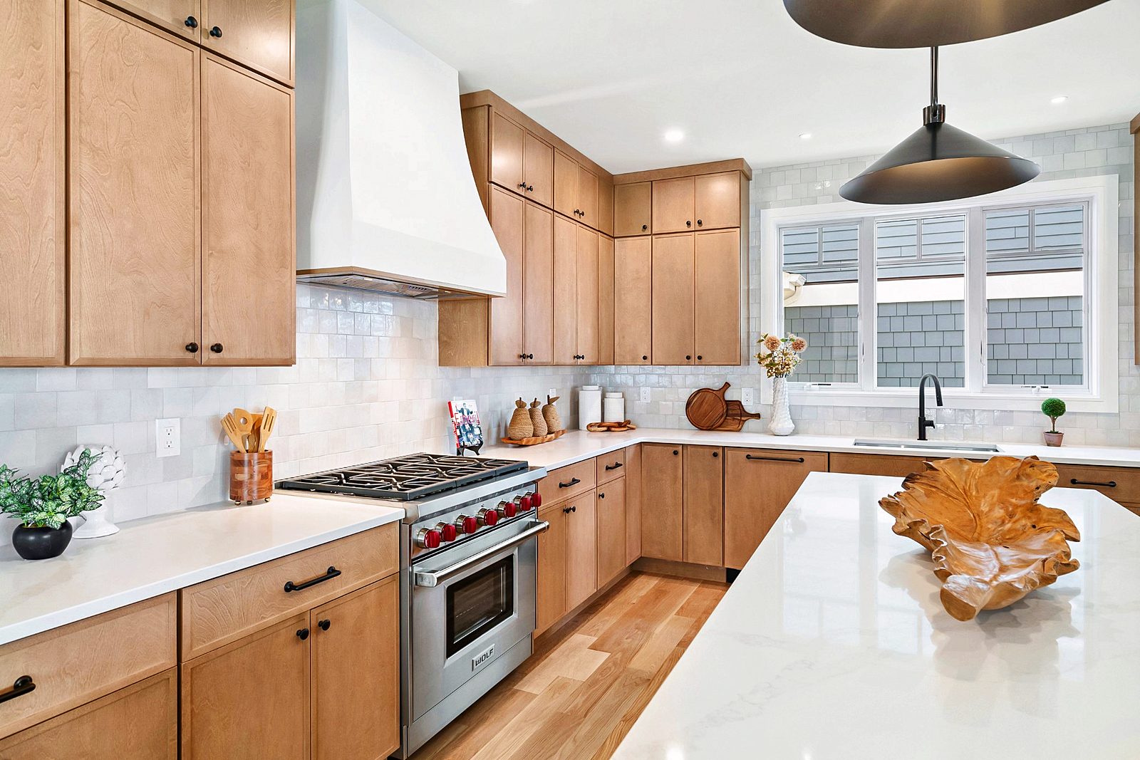 Range wall with Wolf range and white hood