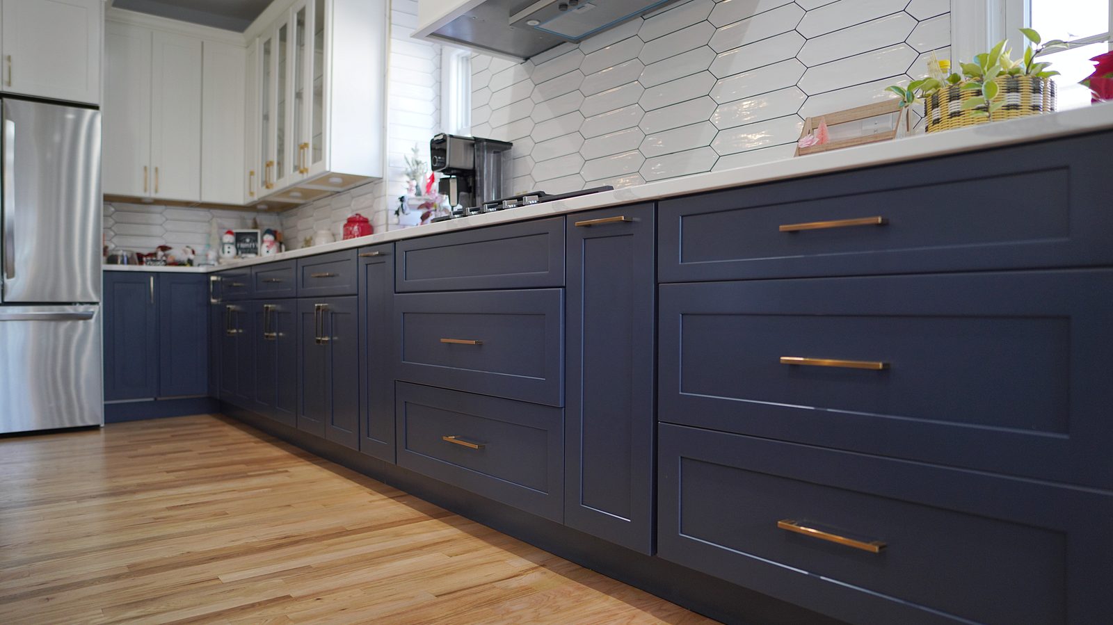 Navy drawers with brass pulls under the marble-look quartz