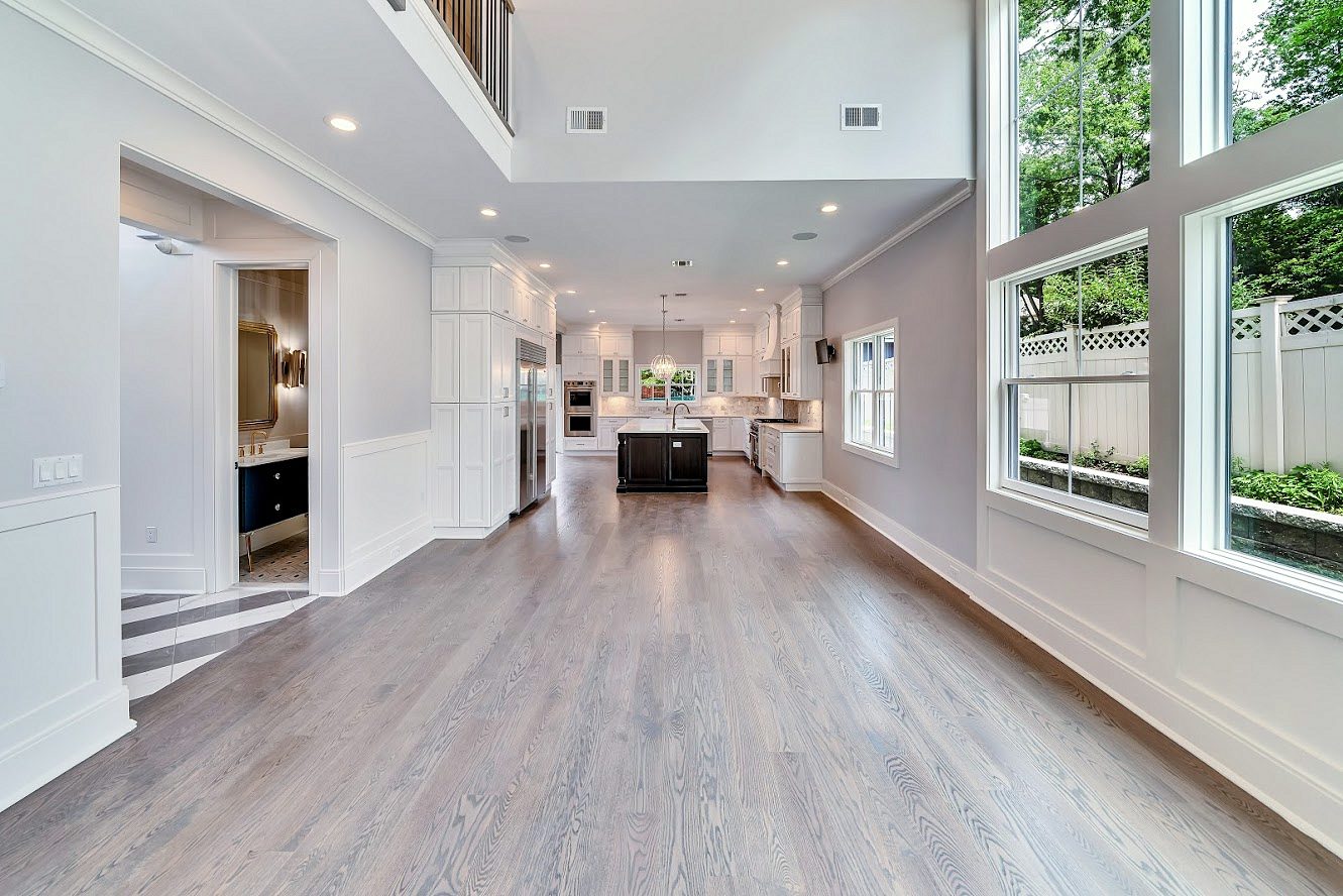 White shaker kitchen with a long charcoal island in a two-story great room — photo 10