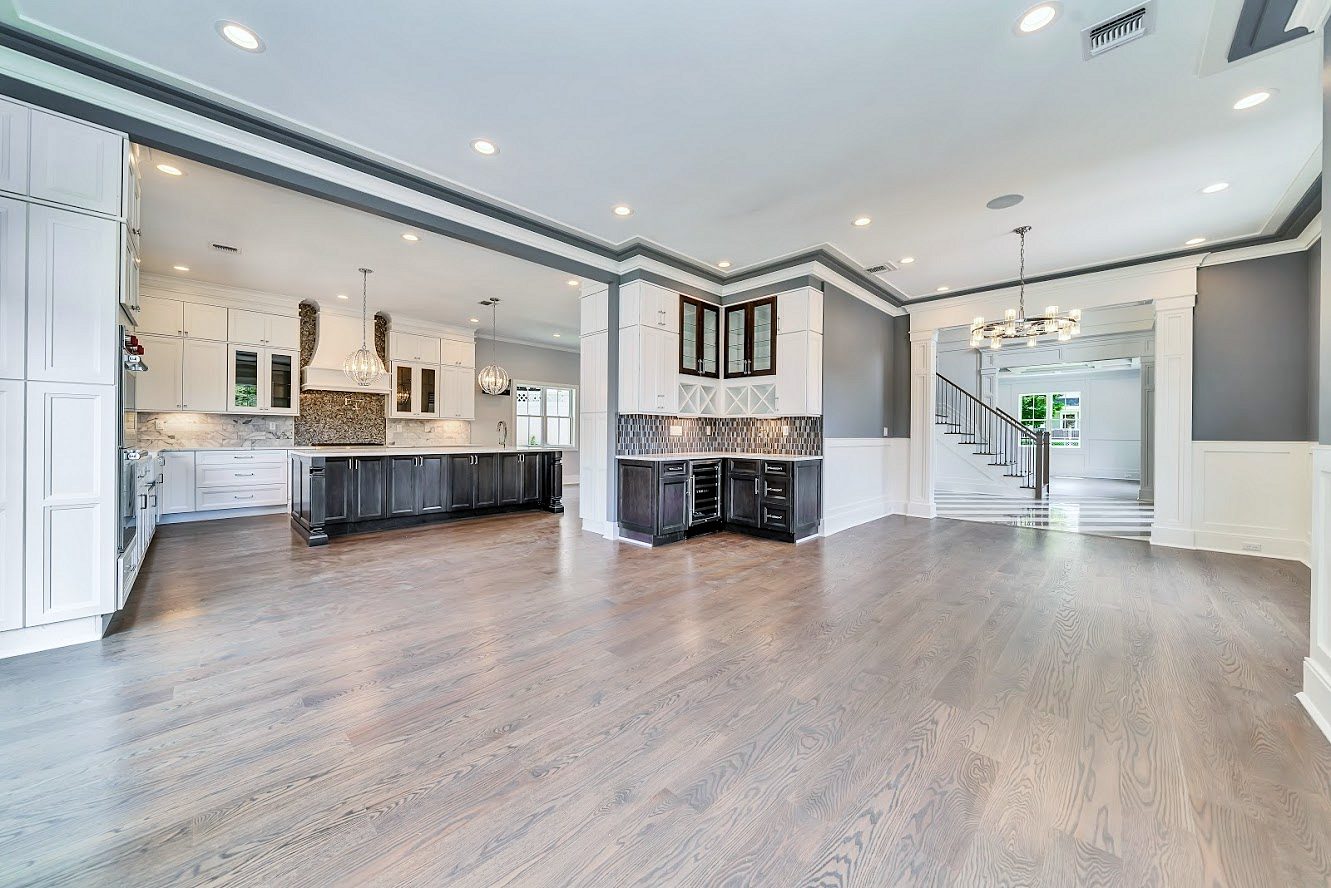 White shaker kitchen with a long charcoal island in a two-story great room — photo 9