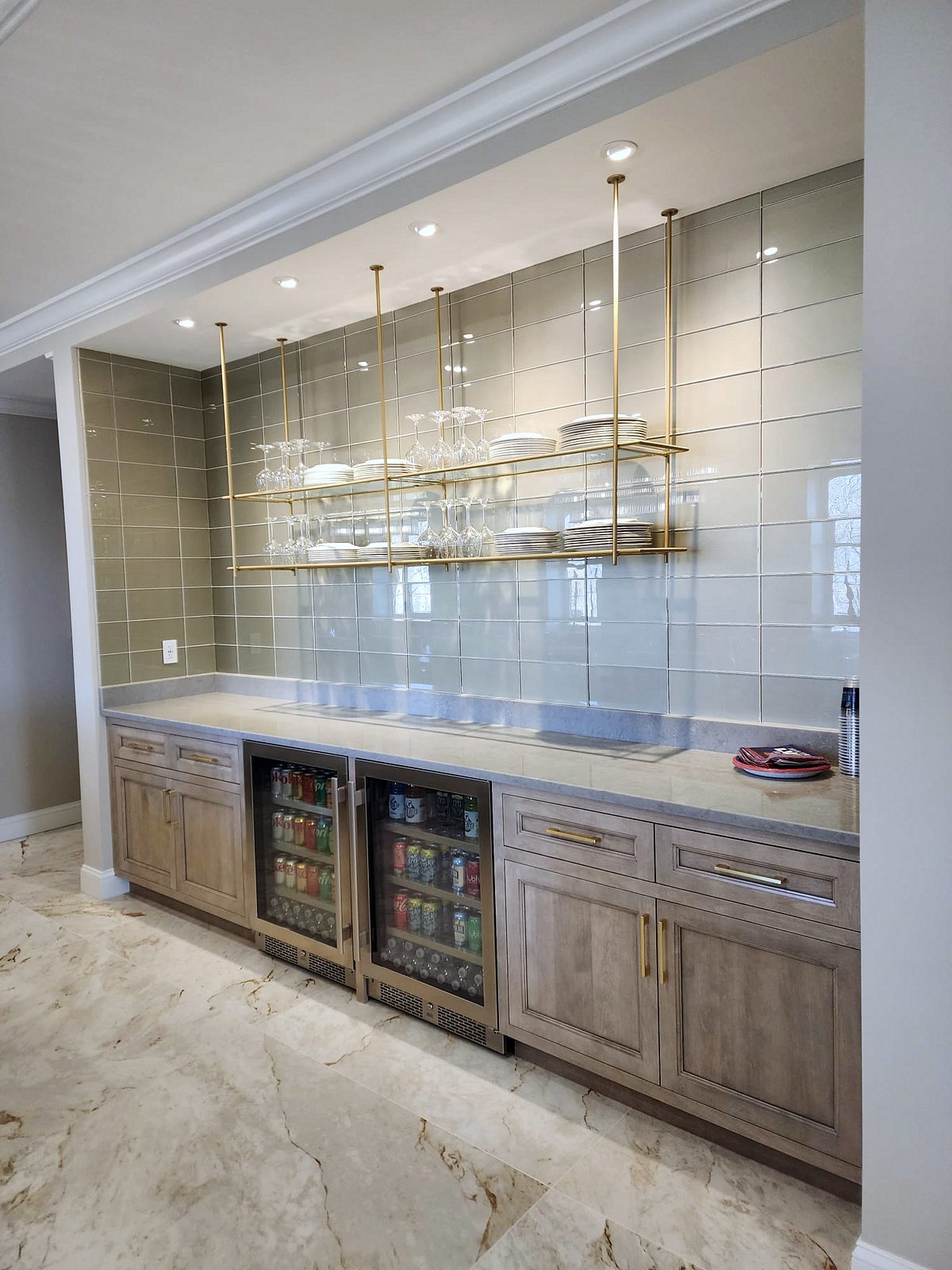 Butler’s pantry with brass-framed glass shelves and a hutch — Shiloh Aspen inset kitchen in a brown stain with a lit bar wall and a butler’s pantry