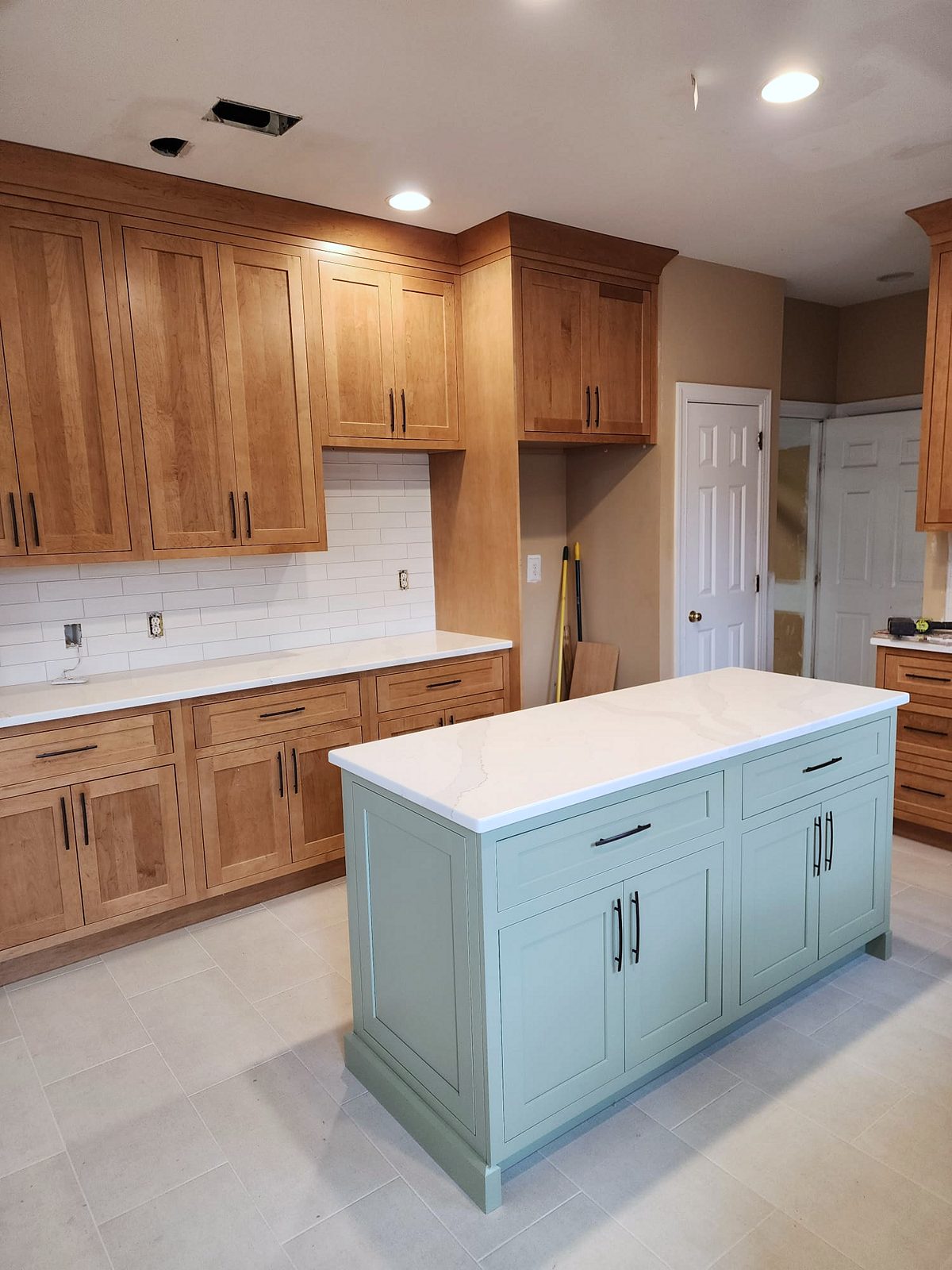 Shiloh Hanover door, light brown stain (archive label) — Shiloh Hanover kitchen in a light brown stain with a green island