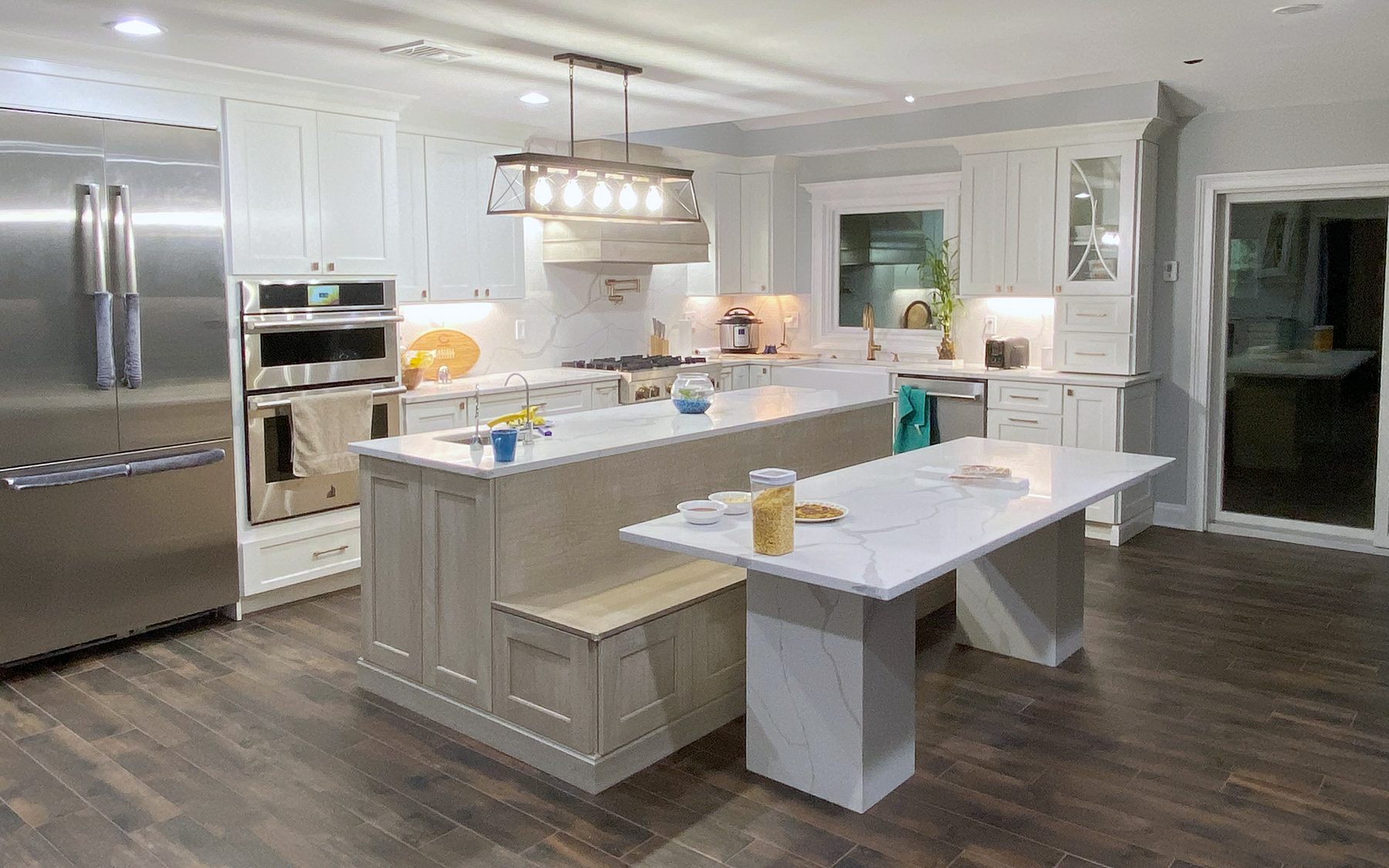 Shiloh Heritage kitchen in Polar and Seagull with a bench island and a gray wood hood