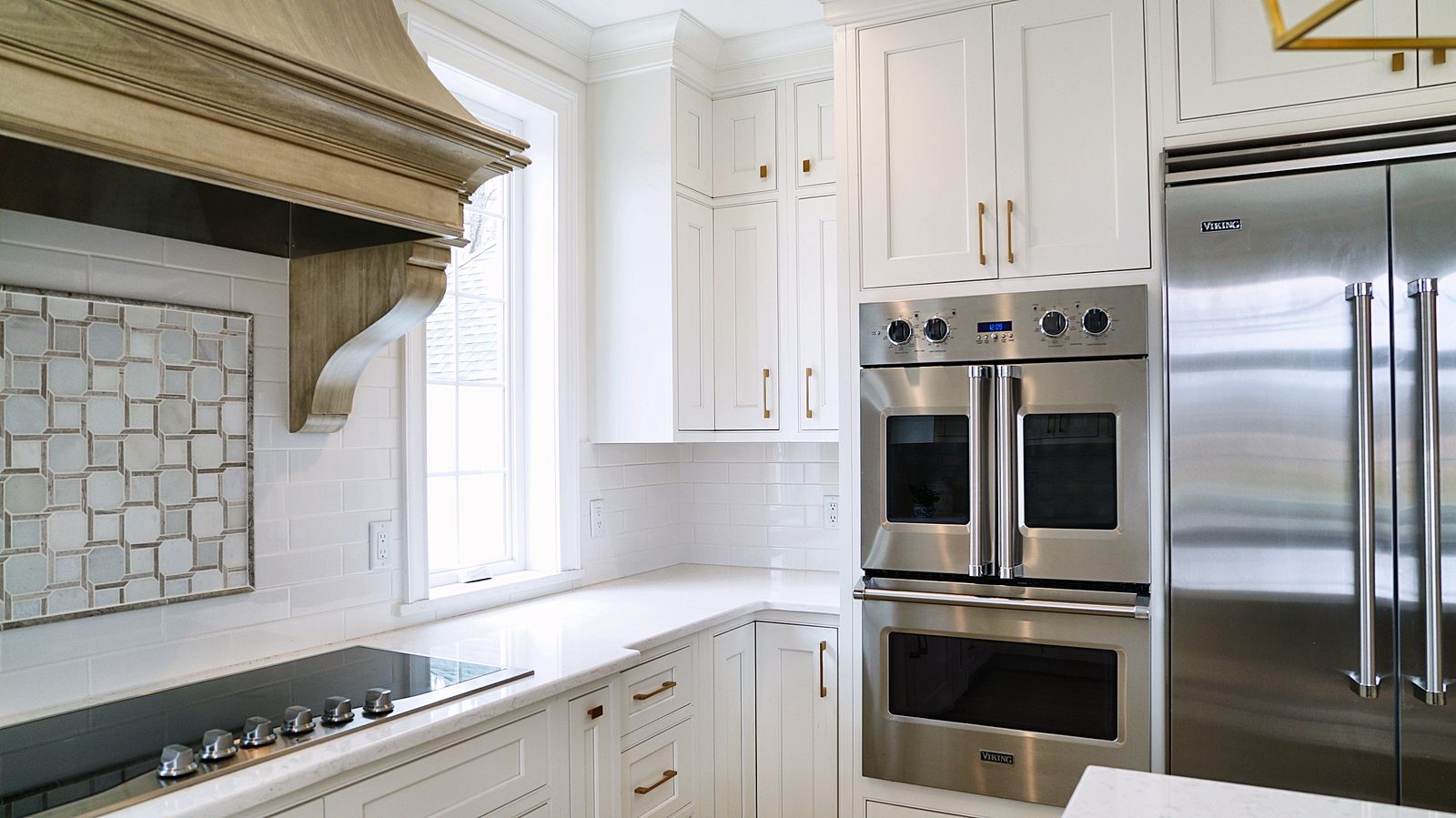 Marble mosaic backsplash under a carved wood hood