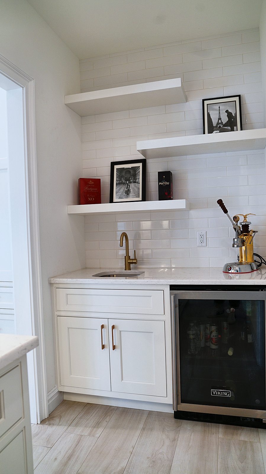 Bar with a wine refrigerator and floating shelves off the kitchen