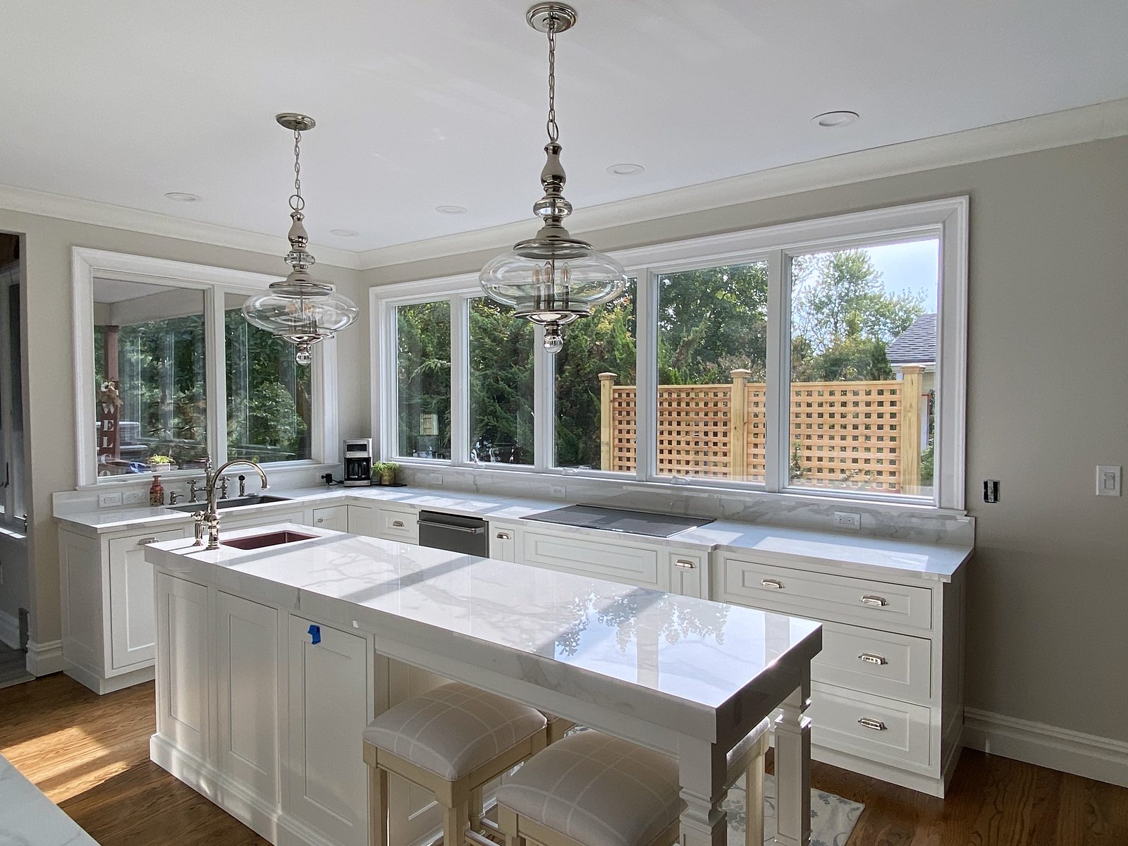 Calacatta-look quartz island — Shiloh Heritage in Polar with mullion uppers and a window wall