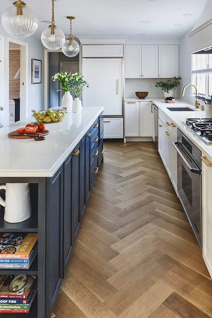 White kitchen with navy island and brass pulls
