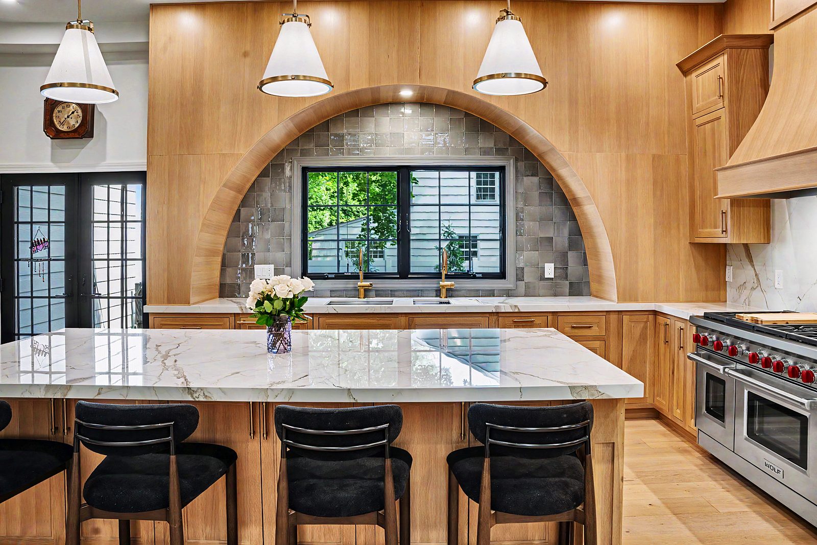 Arched oak alcove with gray tile and brass faucet