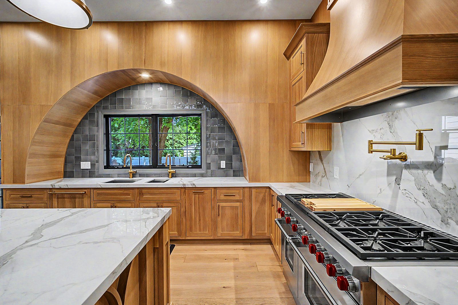 Wolf range, brass pot filler and oak hood surround