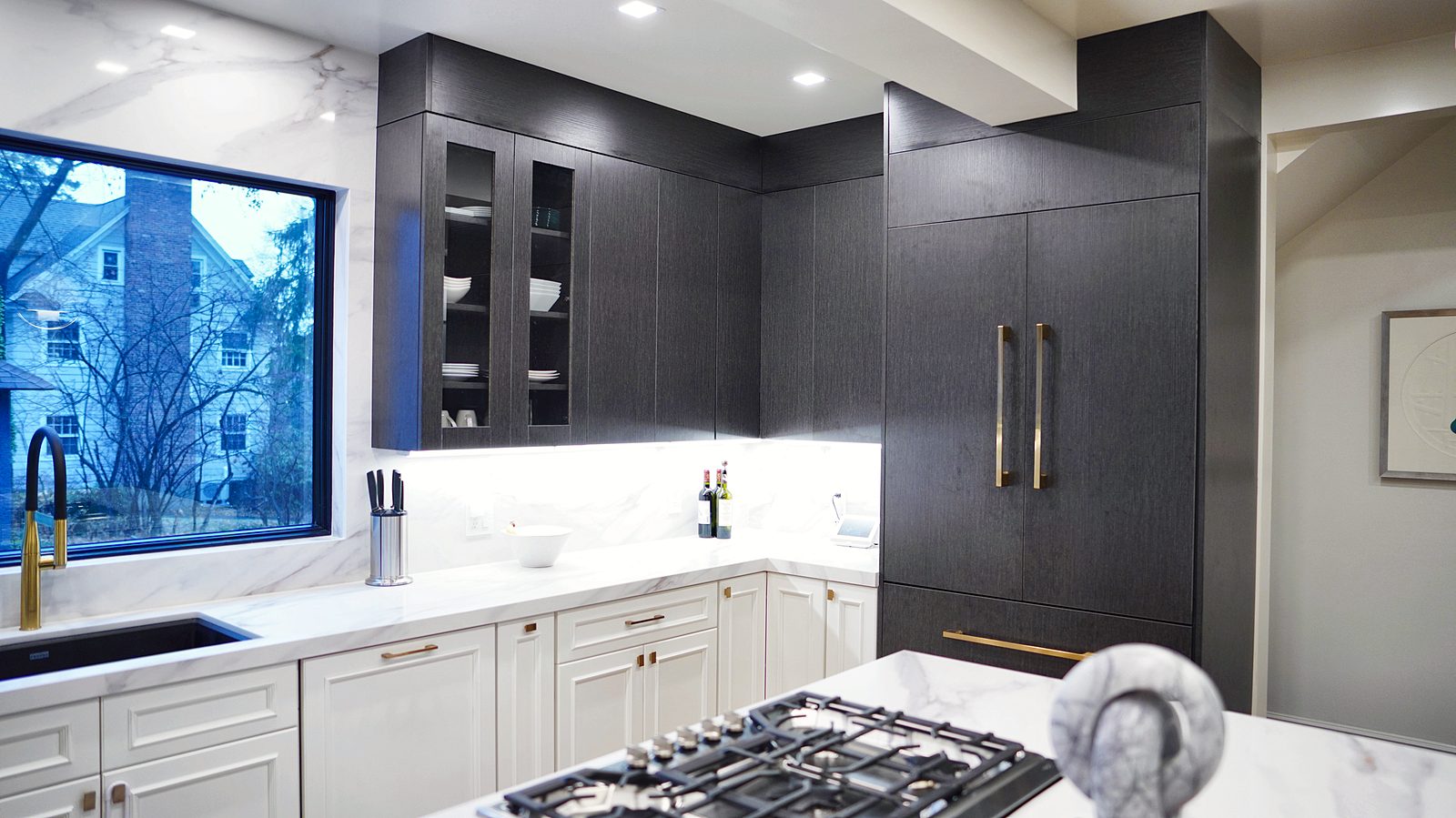Cooktop in the island with the black wall beyond