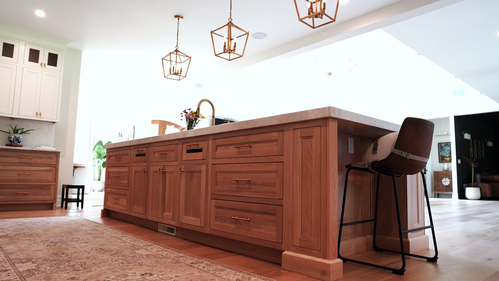 End of the wood island with a stool, under the lantern pendants