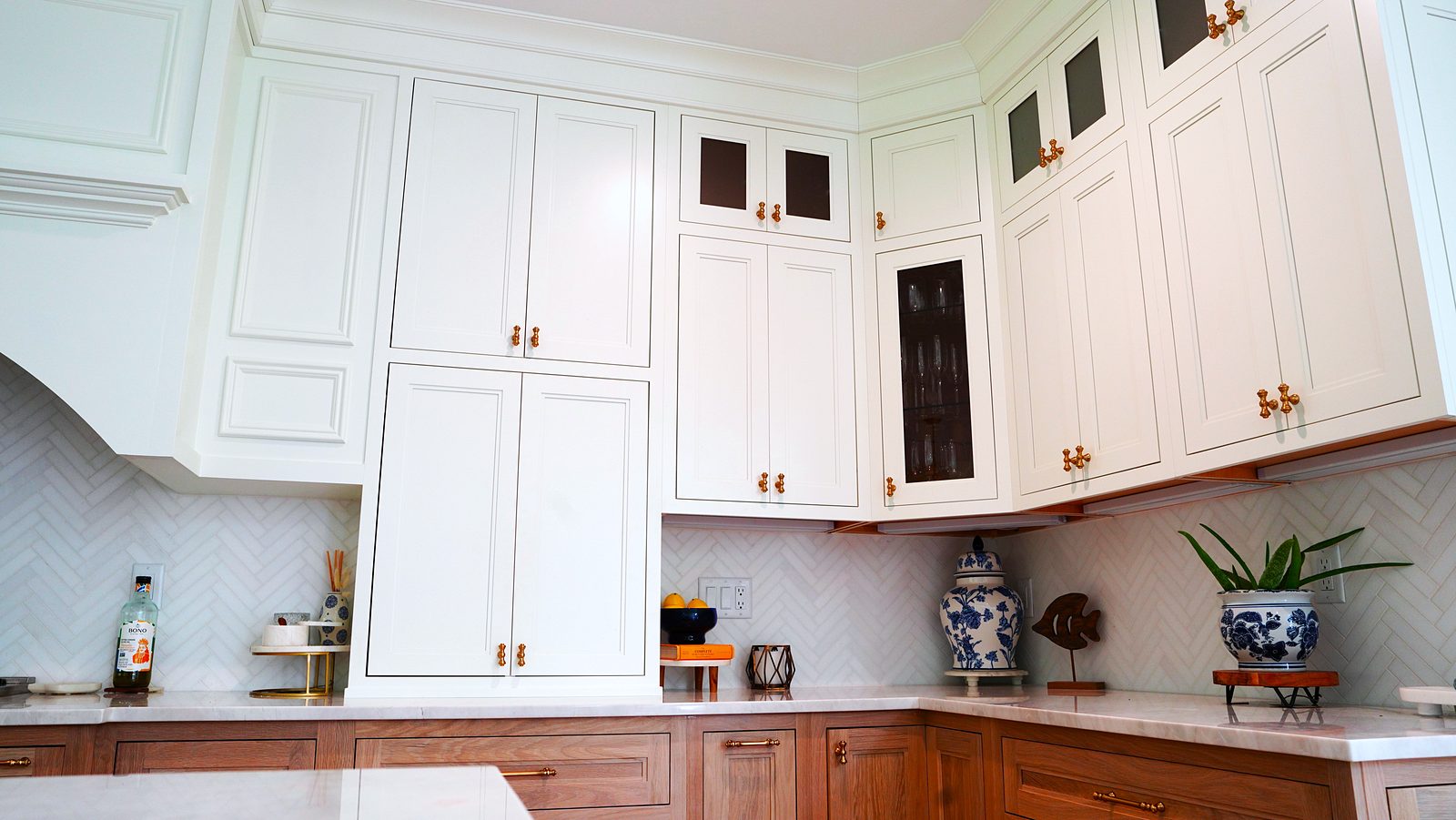 White shaker uppers with small glass panes over the wood base cabinets