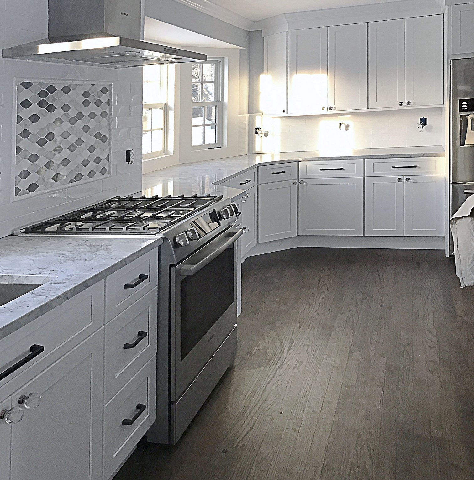 Dark gray furniture-style island on turned legs — White shaker kitchen with a dark gray furniture-style island