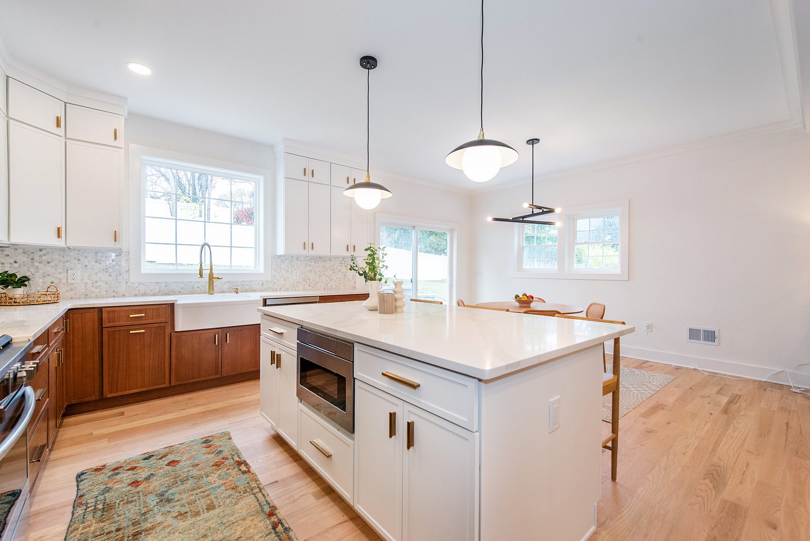White island with a microwave drawer and a veined quartz top, seen from the sink side