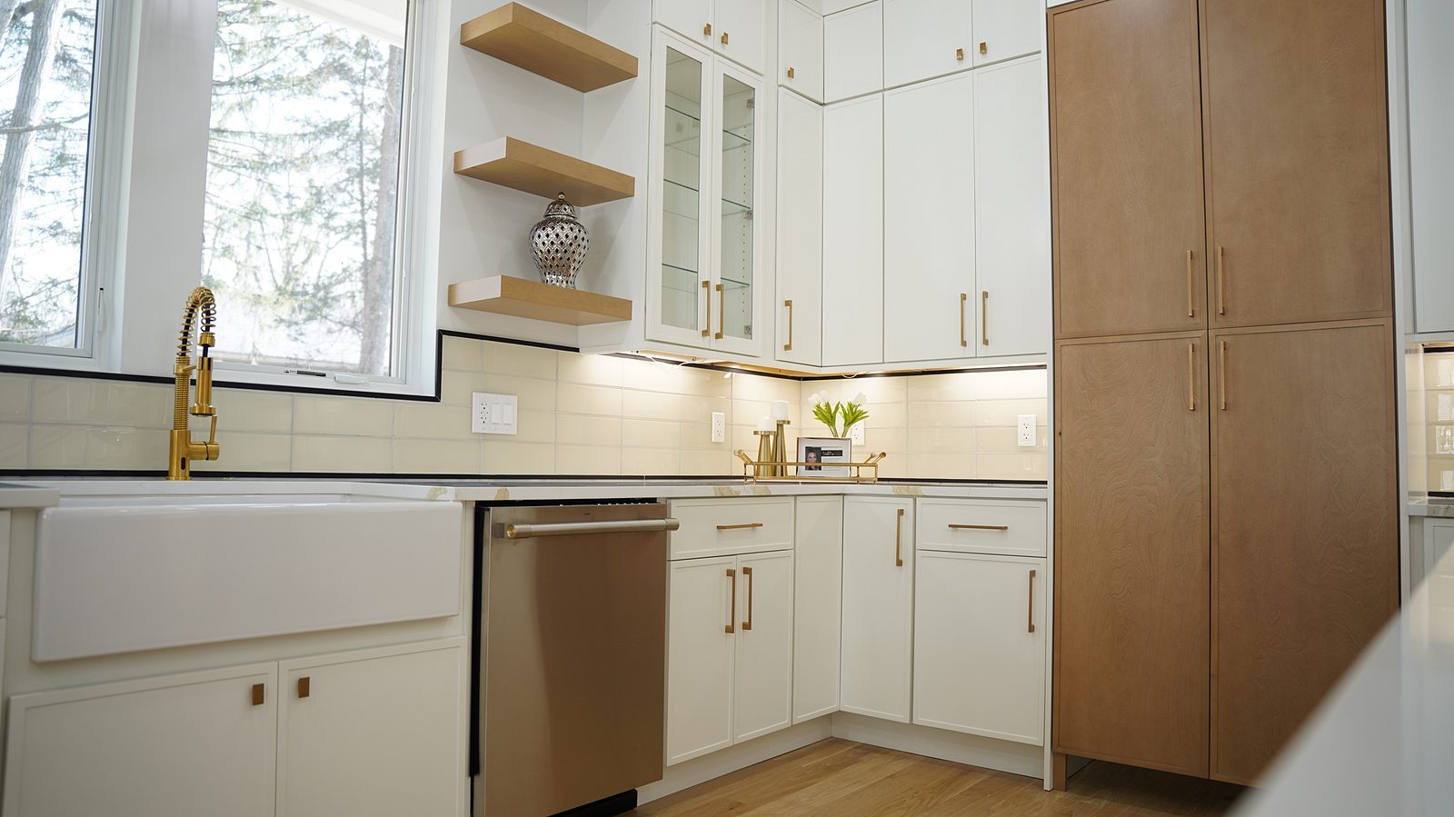 Corner of the kitchen with the oak pantry cabinets and brass bar pulls