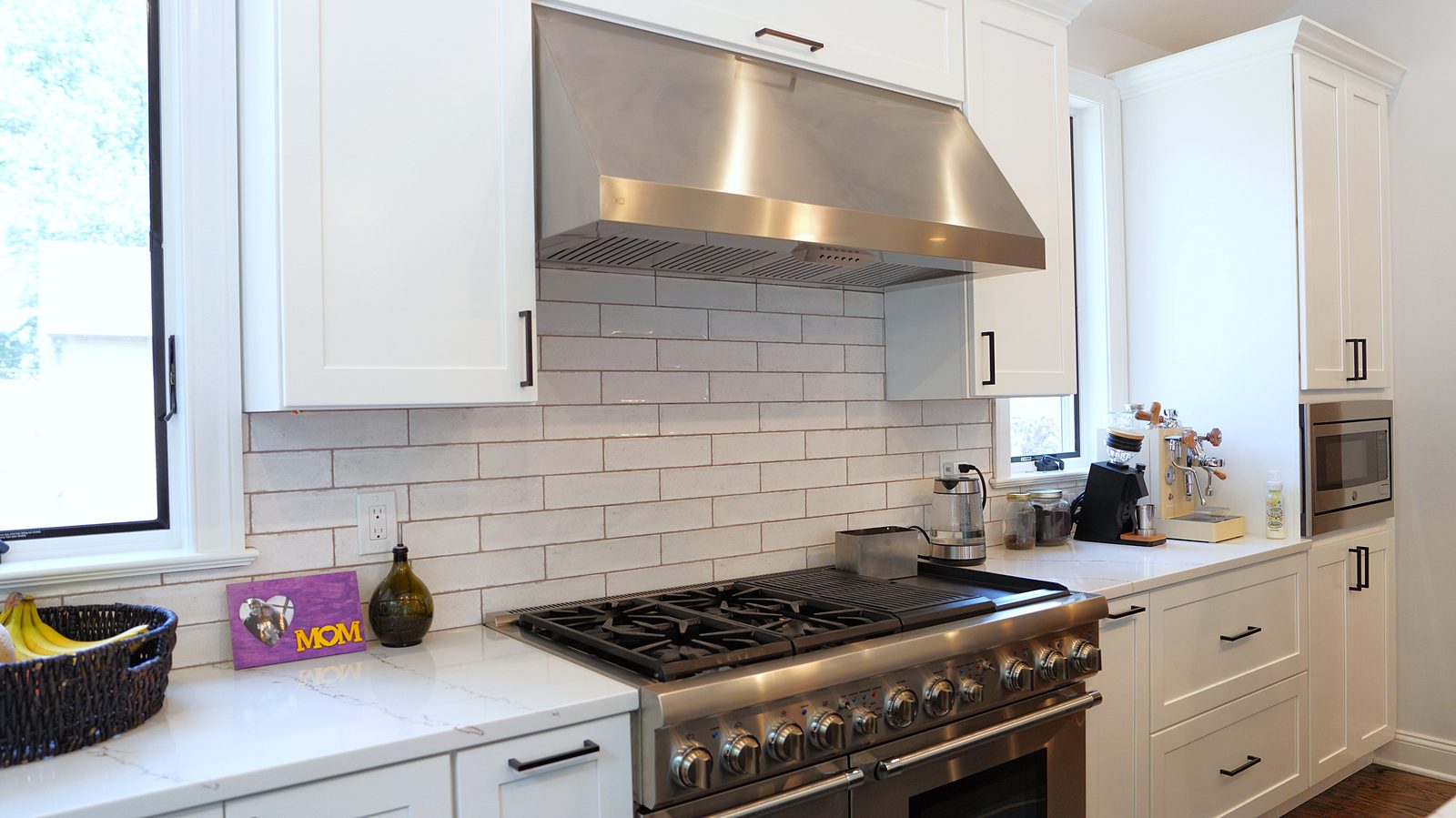 Pro-style range and stainless hood with the gray glazed subway tile
