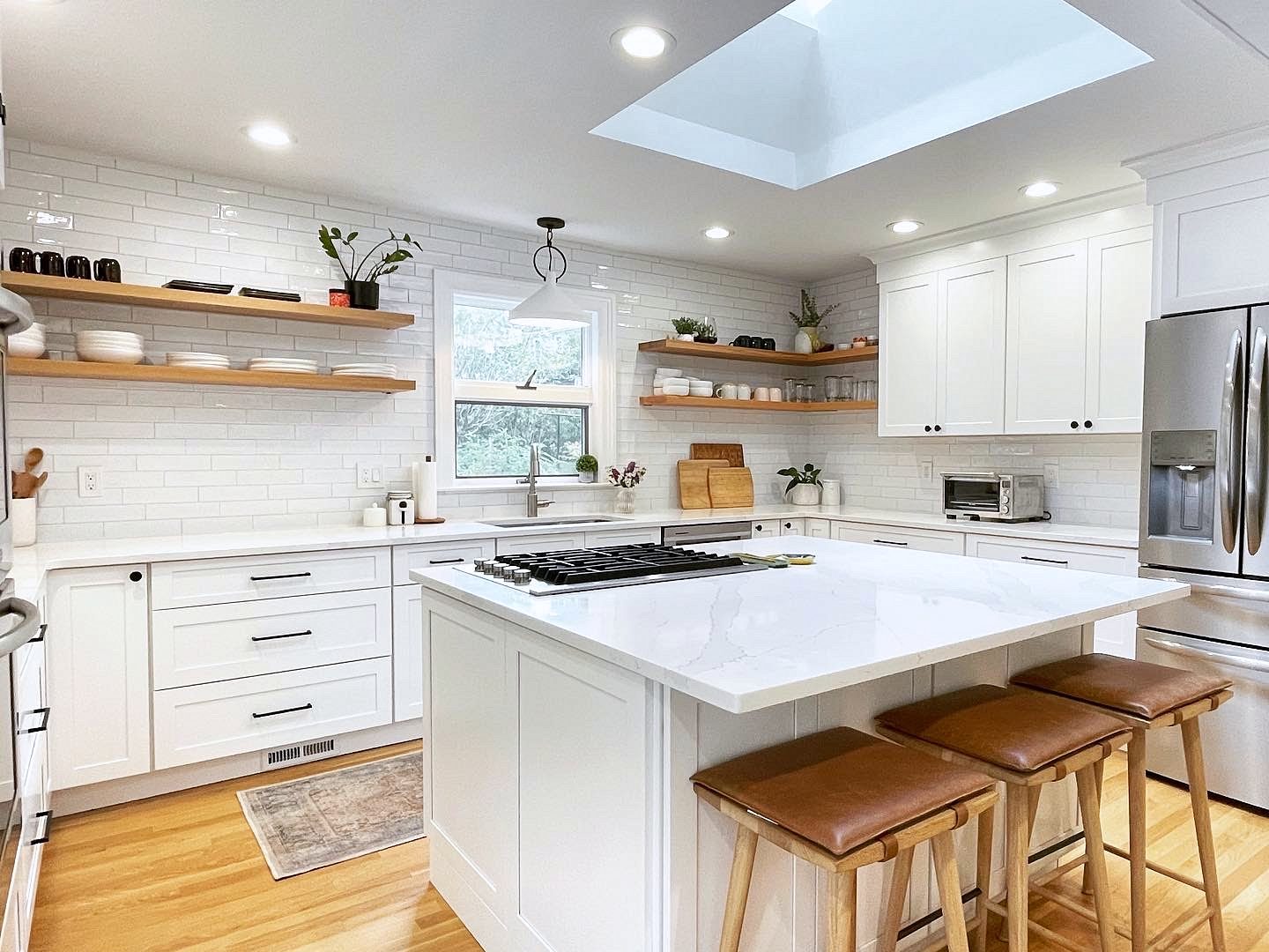 White shaker perimeter with wood floating shelves — White shaker kitchen with floating shelves and subway tile to the ceiling