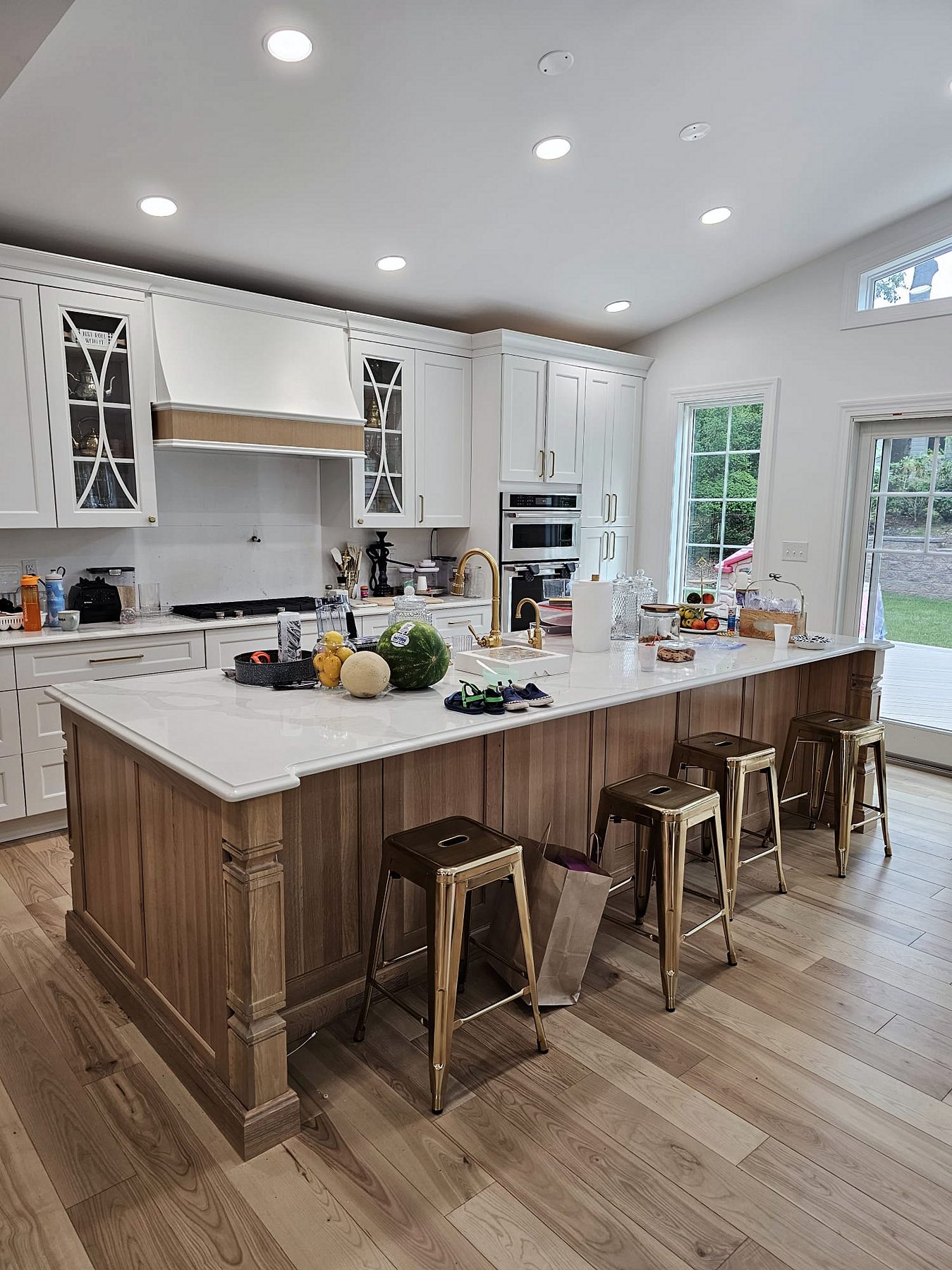 White shaker kitchen with X-mullion glass uppers and a stained wood island on turned legs