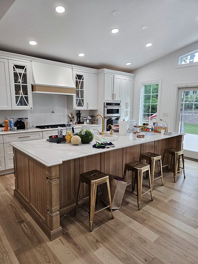 White shaker kitchen with X-mullion glass uppers and a stained wood island on turned legs
