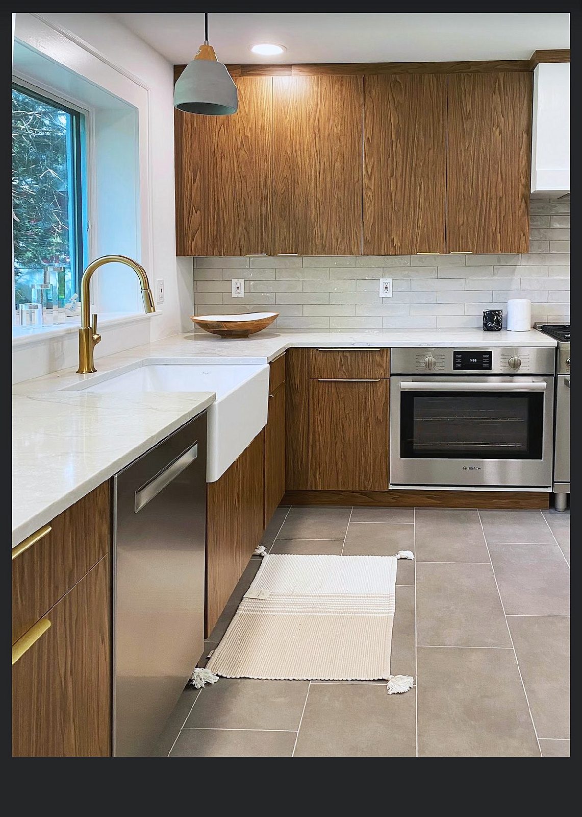 Wood-grain flat-panel doors with brass bar pulls — Wood-grain slab kitchen with brass pulls and a mirrored wine bar