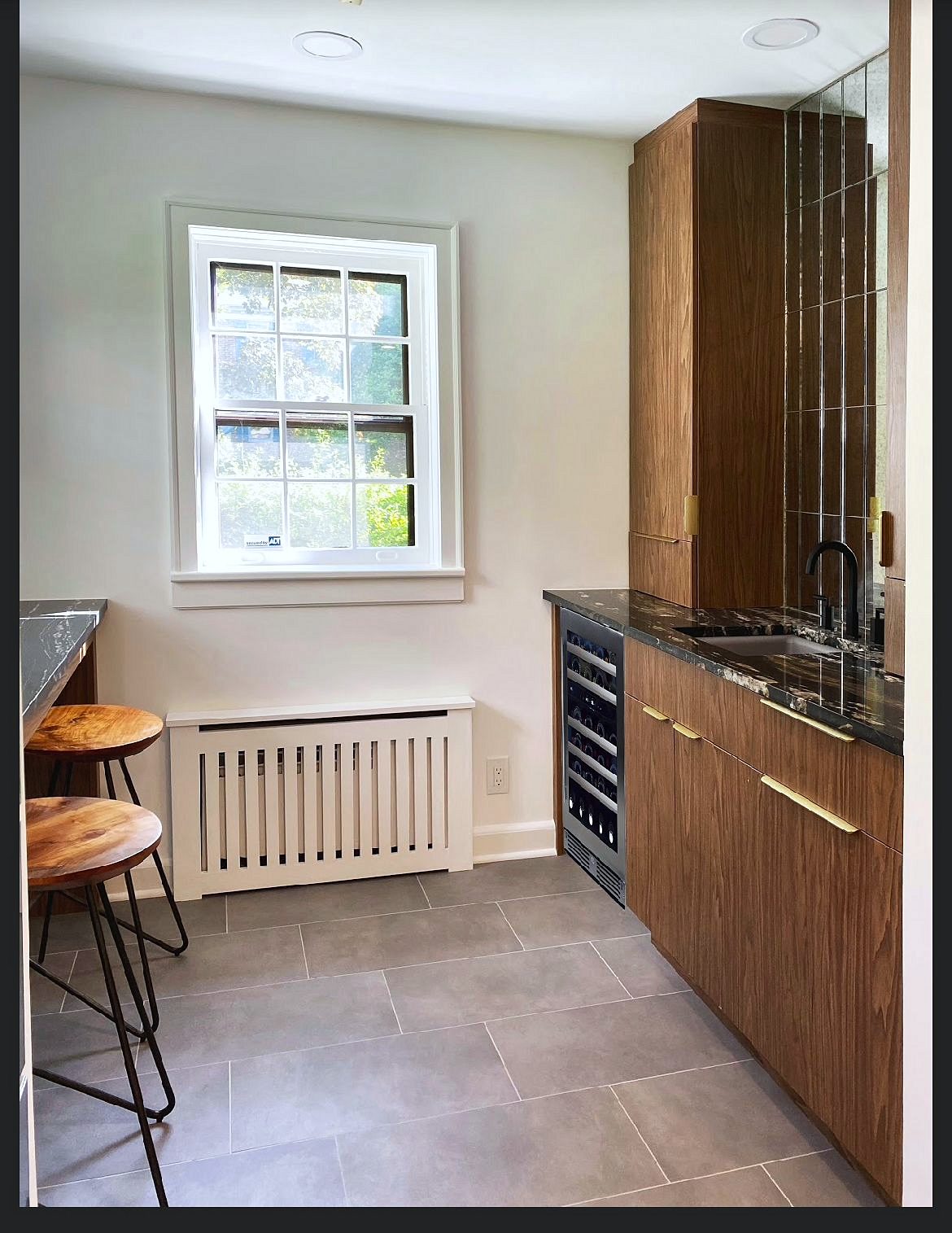 Wood-grain slab kitchen with brass pulls and a mirrored wine bar — photo 6